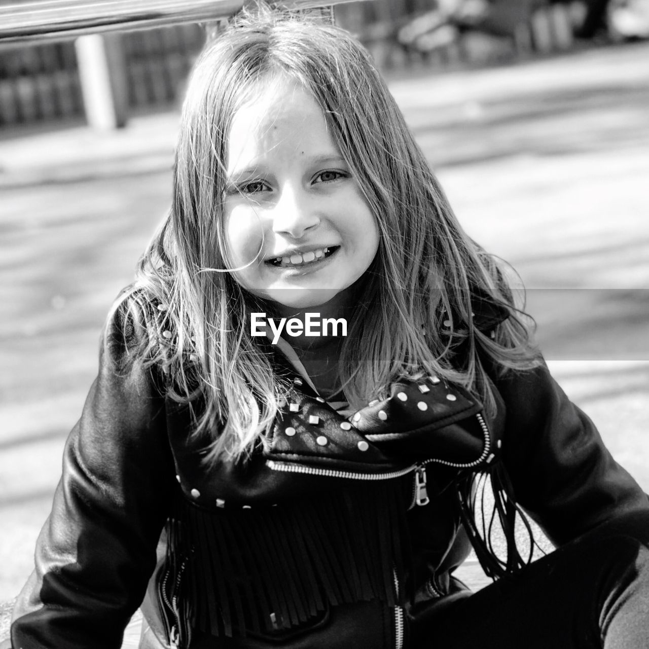 Portrait of smiling girl sitting at outdoors