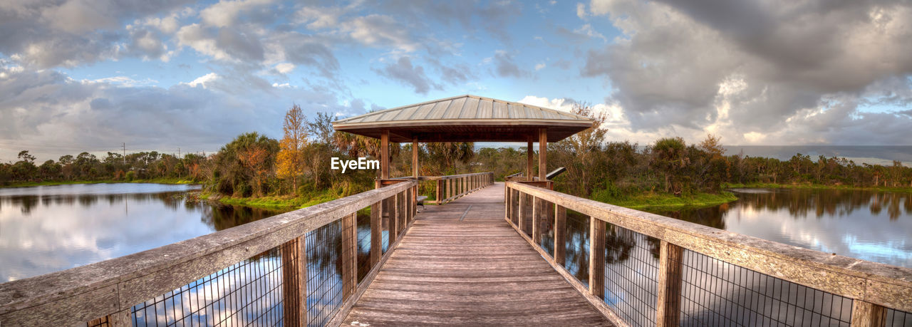 Sunset over gazebo on a wooden secluded, tranquil boardwalk along a marsh pond in freedom park 