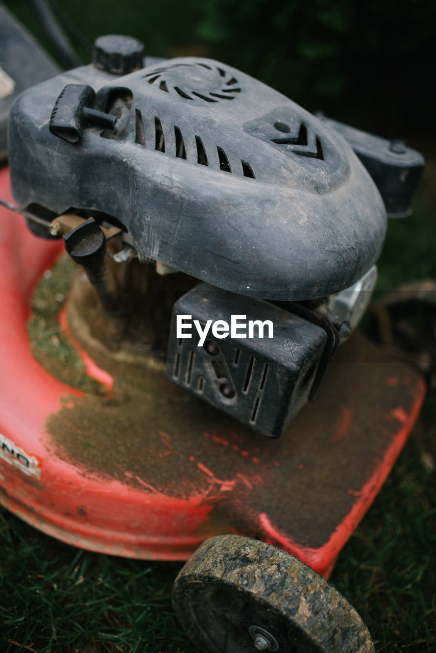 Plastic cover on old and rusty mower.