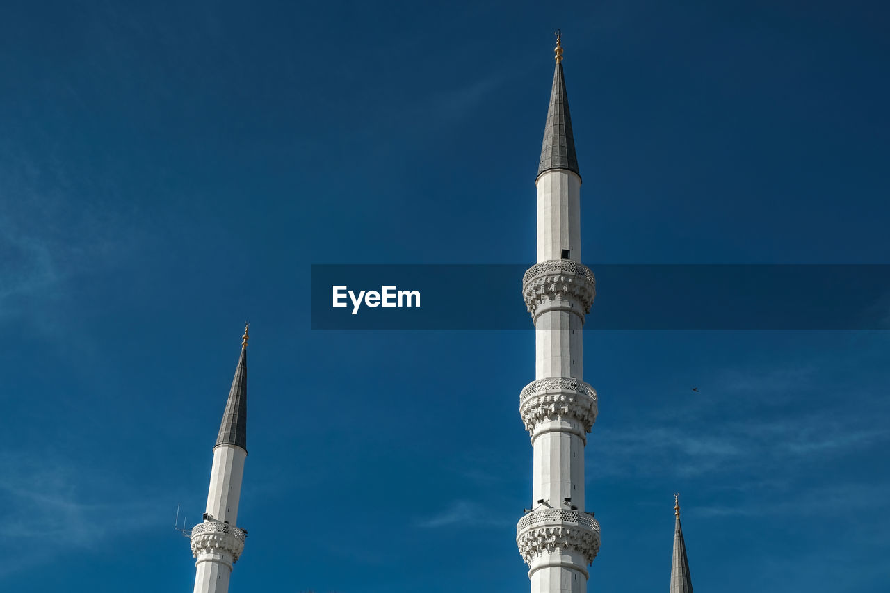 Low angle view of mosque and minaret  against blue sky