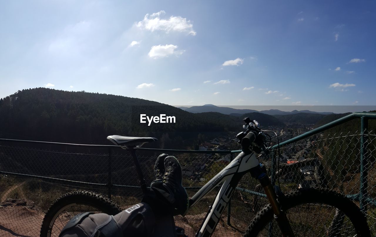 Low section of person with bicycle against mountains