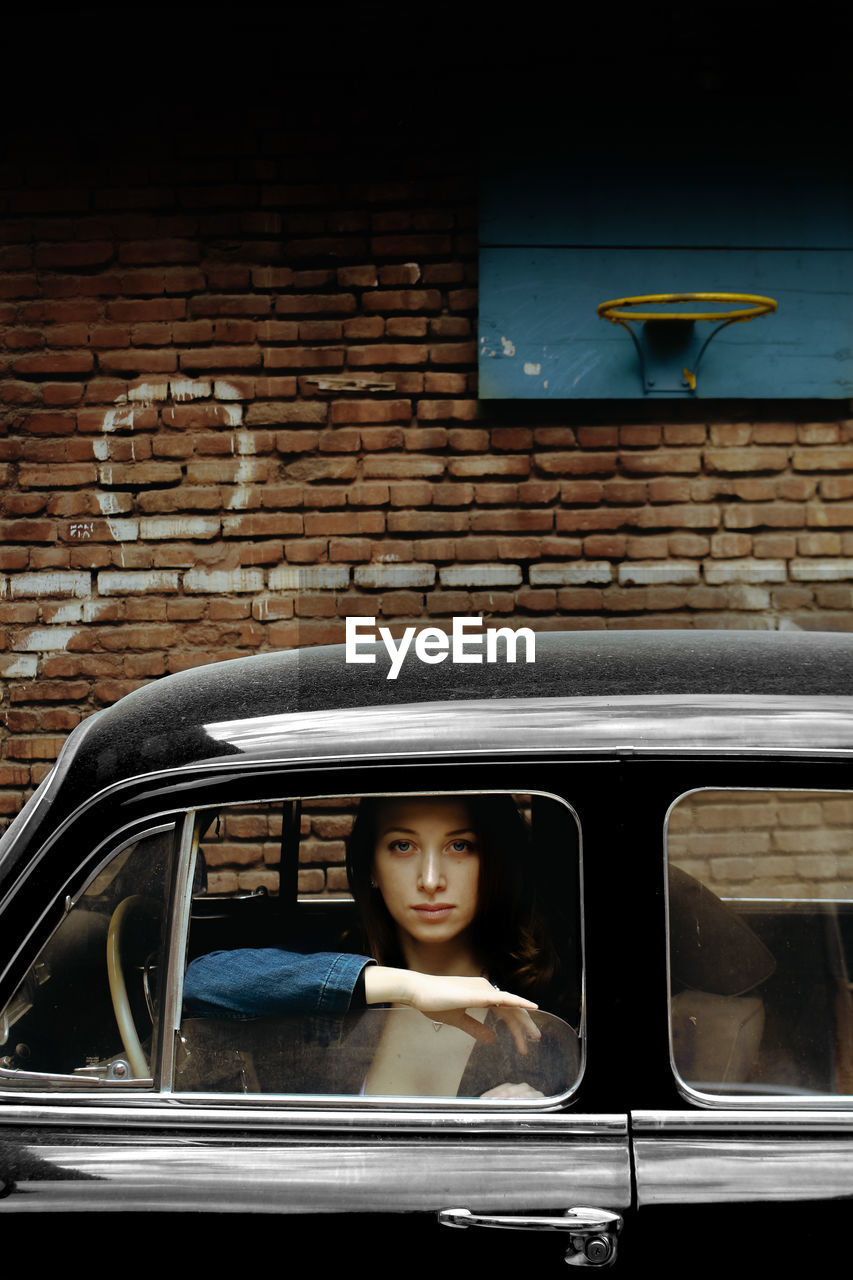 Portrait of woman sitting in car window