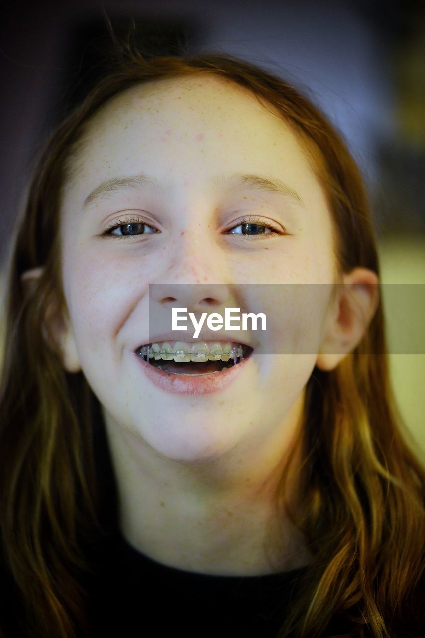 Close-up portrait of smiling girl at home