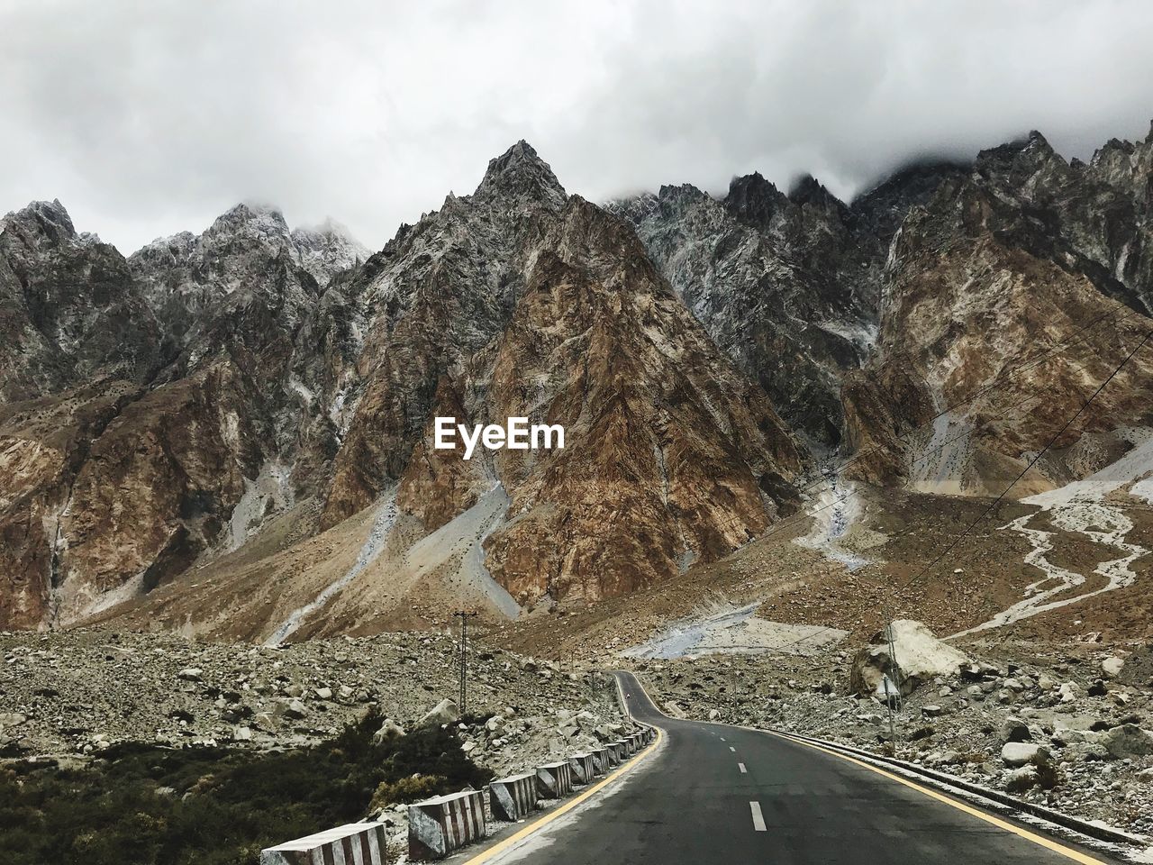 Road leading towards mountains against sky