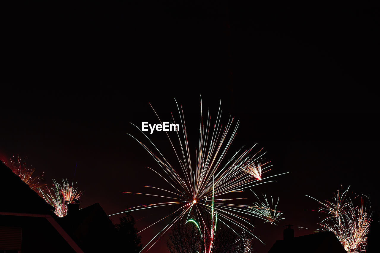 LOW ANGLE VIEW OF FIREWORKS DISPLAY AGAINST SKY AT NIGHT