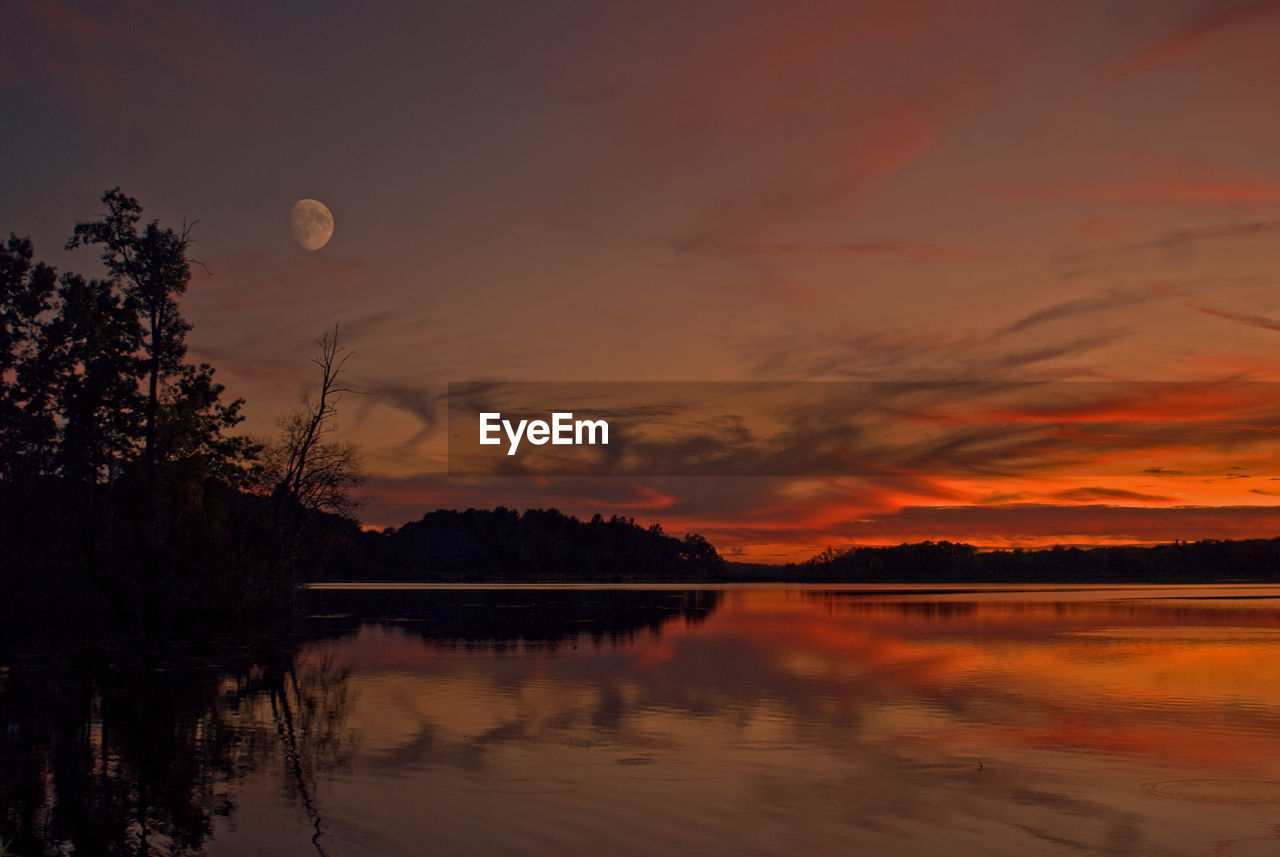 Scenic view of lake against sky at sunset