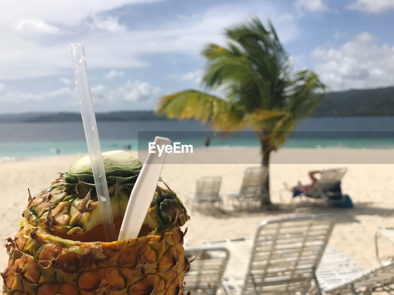 Close-up of drink at beach against sky