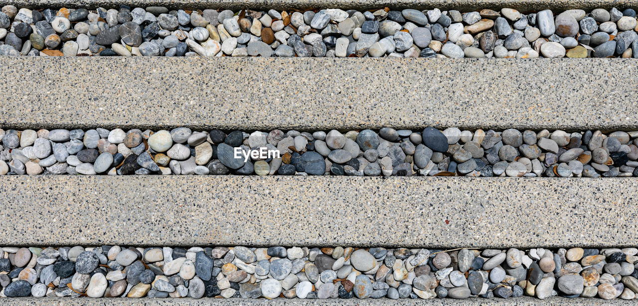 road surface, stone, no people, gravel, day, backgrounds, wall, full frame, asphalt, cobblestone, transportation, textured, rubble, pattern, rock, outdoors, large group of objects, high angle view, road, stone wall, abundance, pebble, gray, architecture, stone material, nature, railroad track, street, flooring, track, city, repetition, built structure, rough