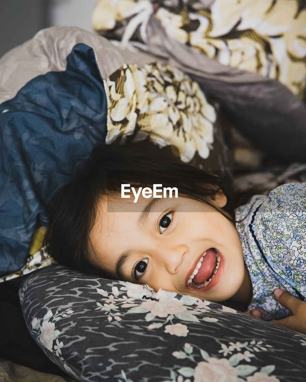 Portrait of cute girl relaxing on bed at home