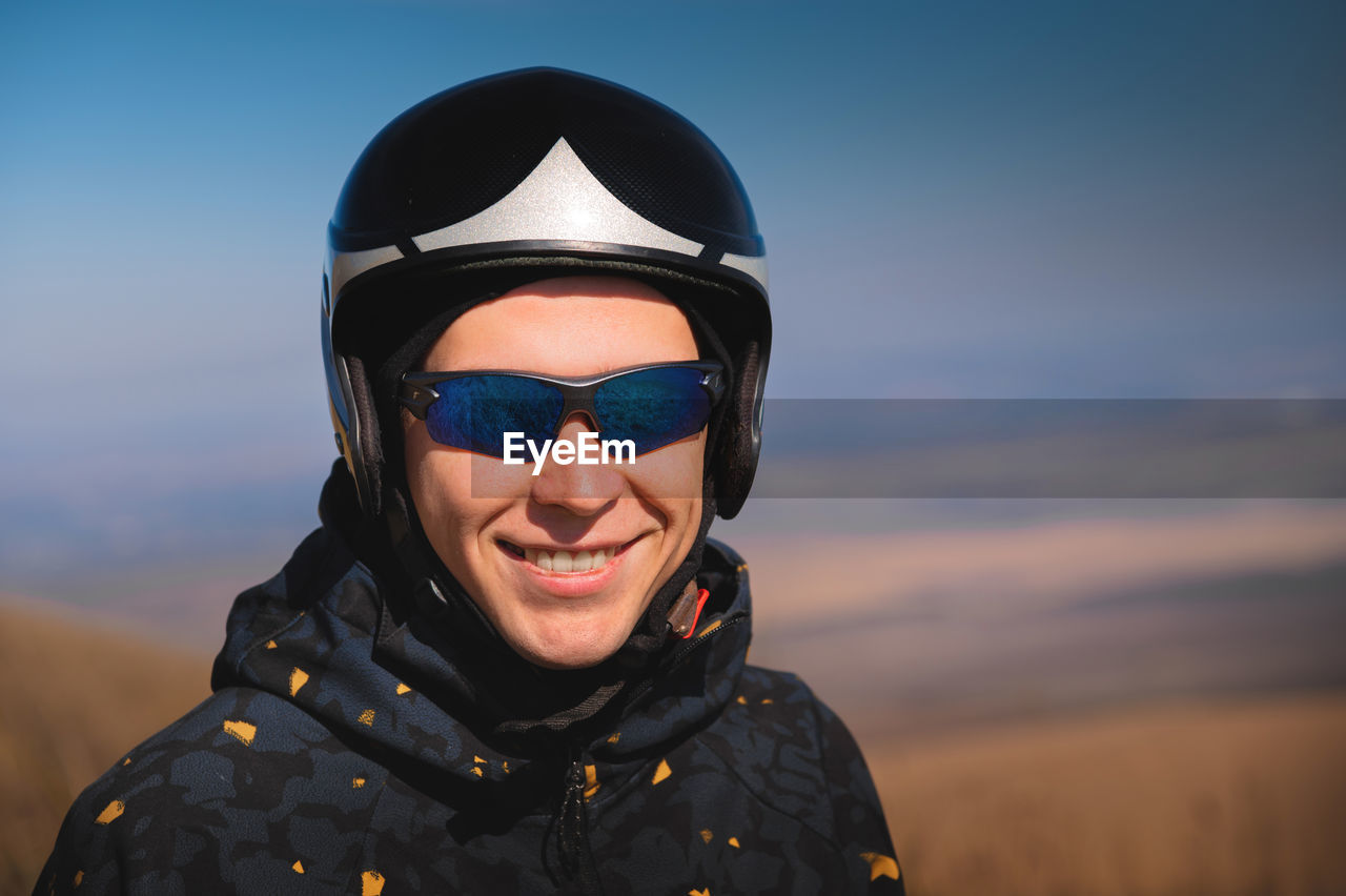 Portrait of a smiling young man with a parachute in a field. a guy paraglider in sportswear and a