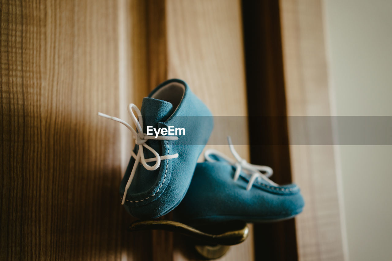 CLOSE-UP OF SHOES ON WOOD