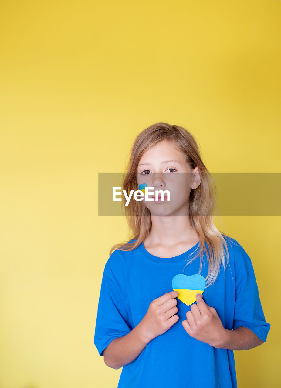 Portrait of girl  against yellow background