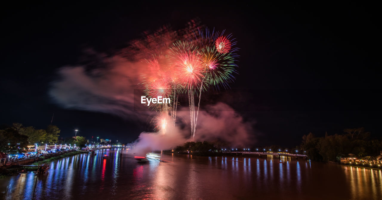 FIREWORK DISPLAY OVER RIVER AGAINST SKY