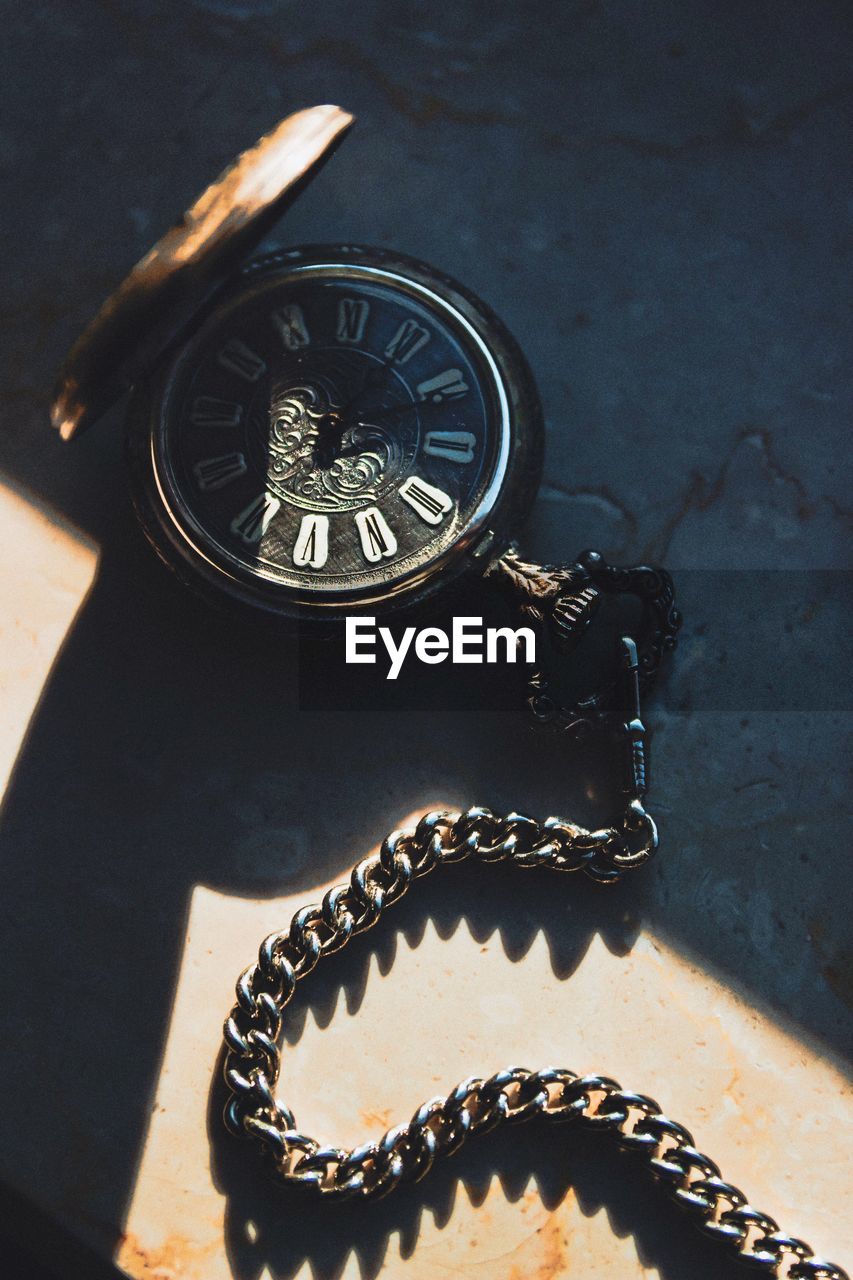 High angle view of pocket watch on table