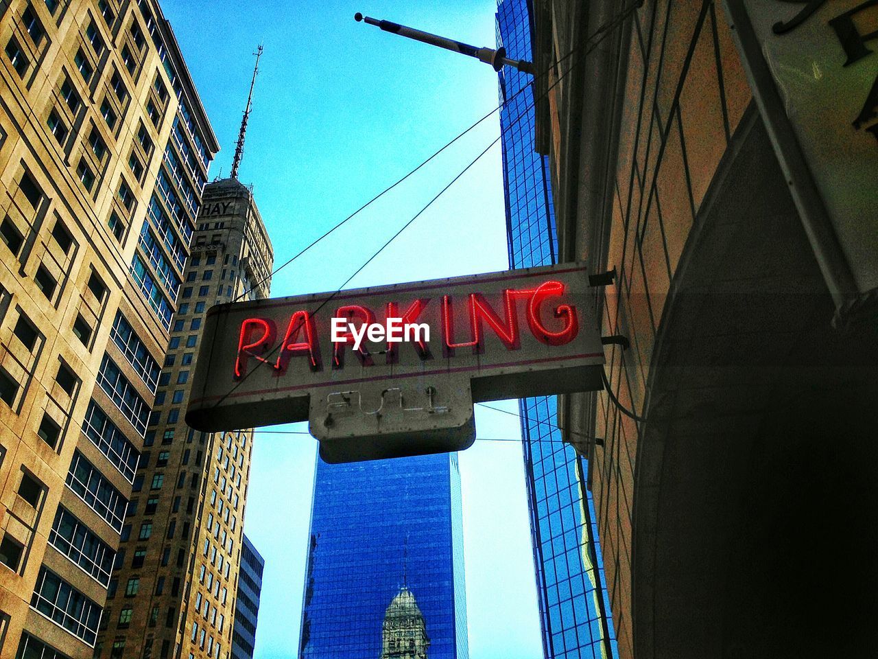 Low angle view of parking text against buildings in city