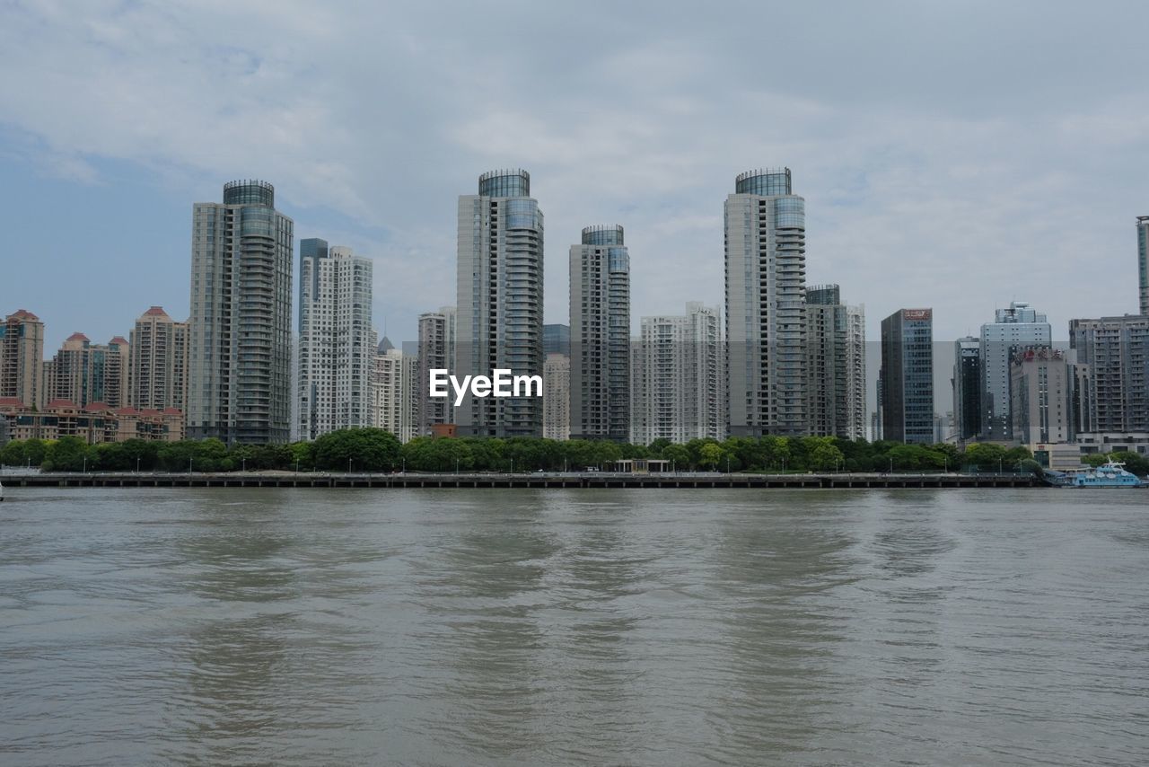 VIEW OF RIVER WITH CITYSCAPE IN BACKGROUND