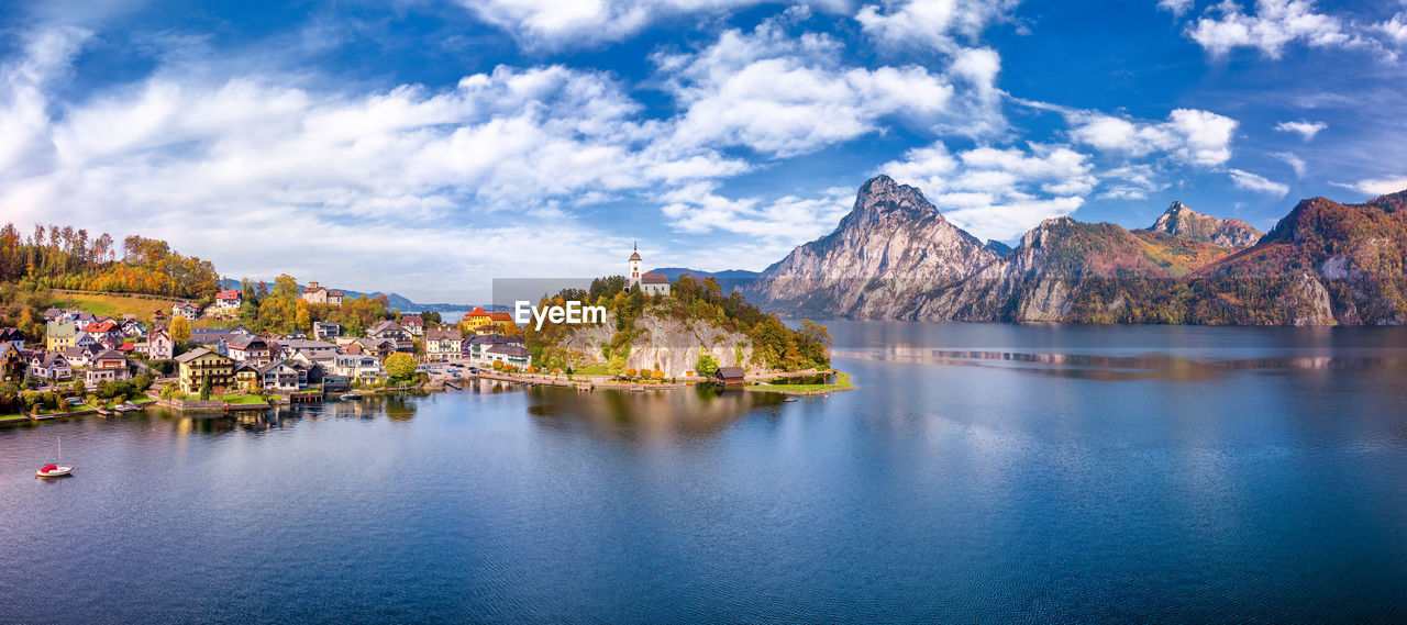 Panoramic shot of buildings by mountains against sky