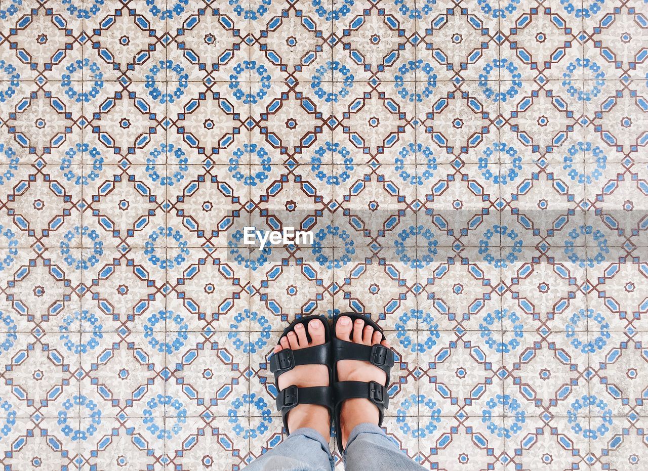 Low section of woman standing on tiled floor