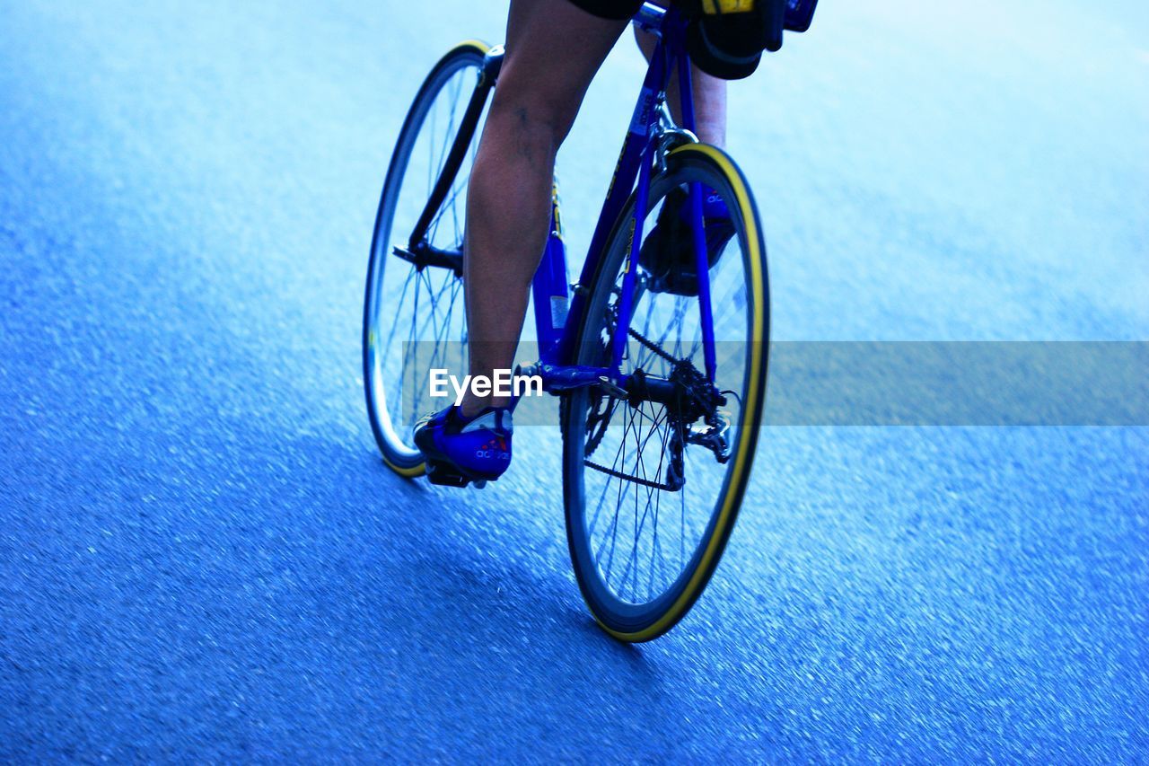 LOW SECTION OF MAN RIDING BICYCLE ON STREET