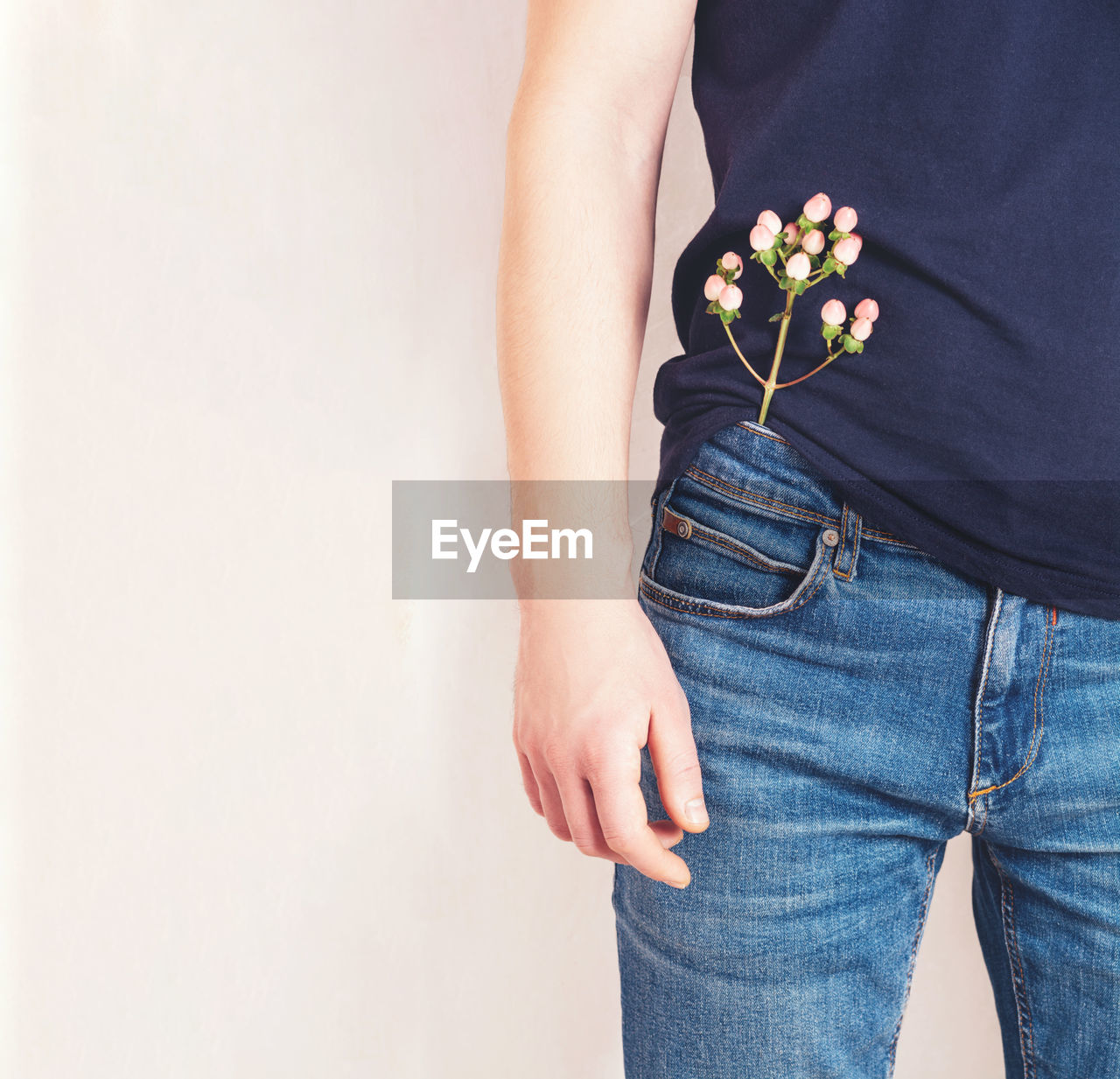 A man in a t-shirt with a flower in his jeans pocket. health,wellness and environmental care concept