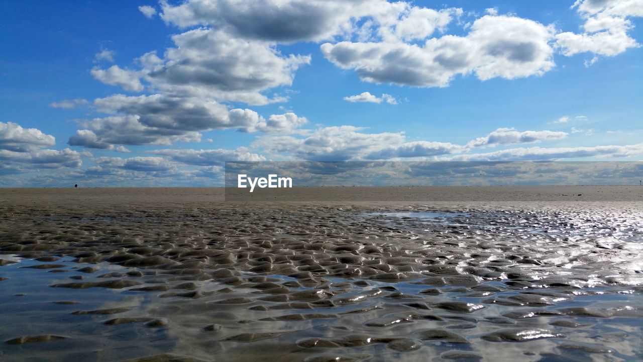 Scenic view of beach against blue sky