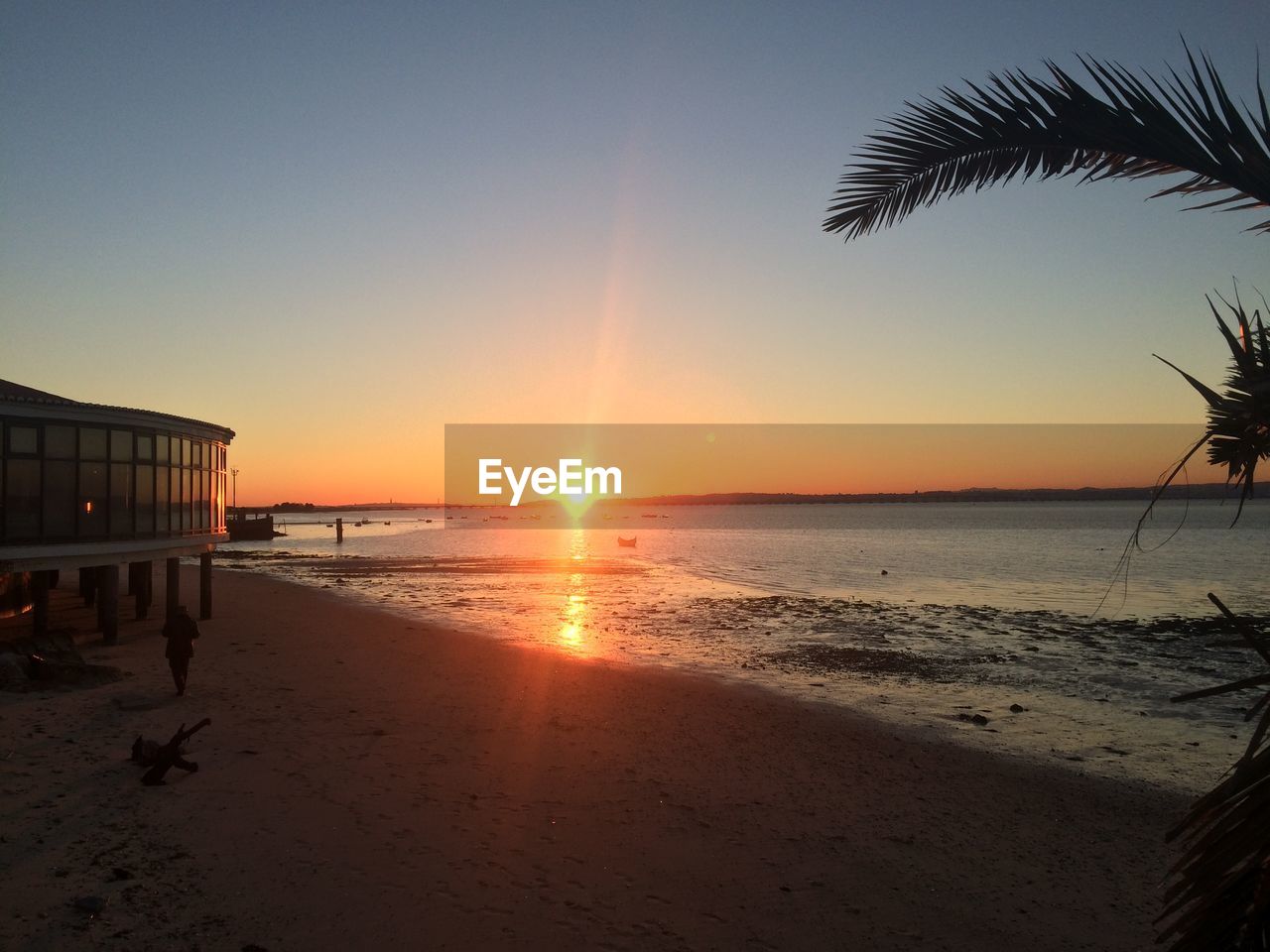 Stilt house at beach during sunset