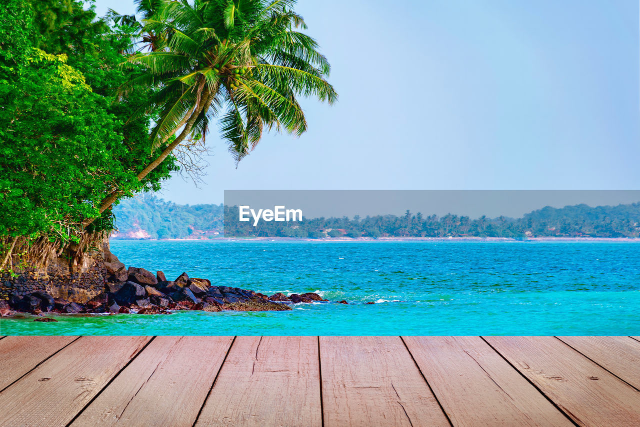 Empty wooden planks with tropical island scene on background. mock up for product display 