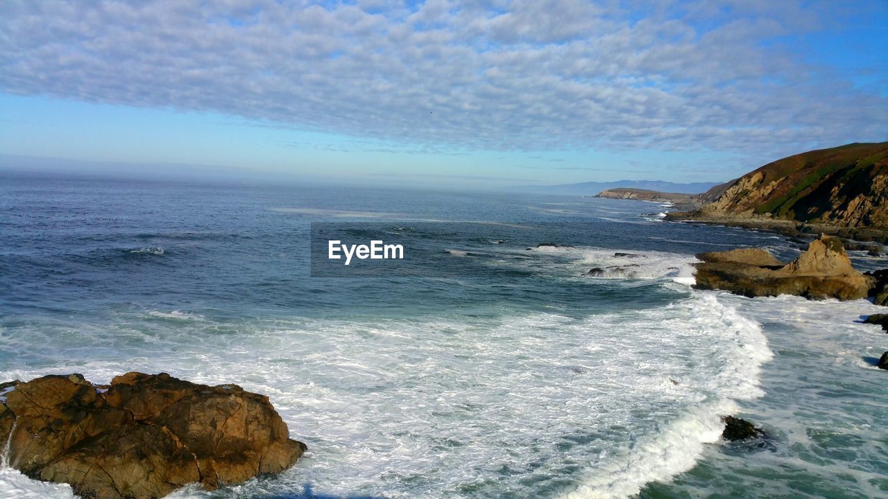 Scenic view of sea against sky with cumulus clouds