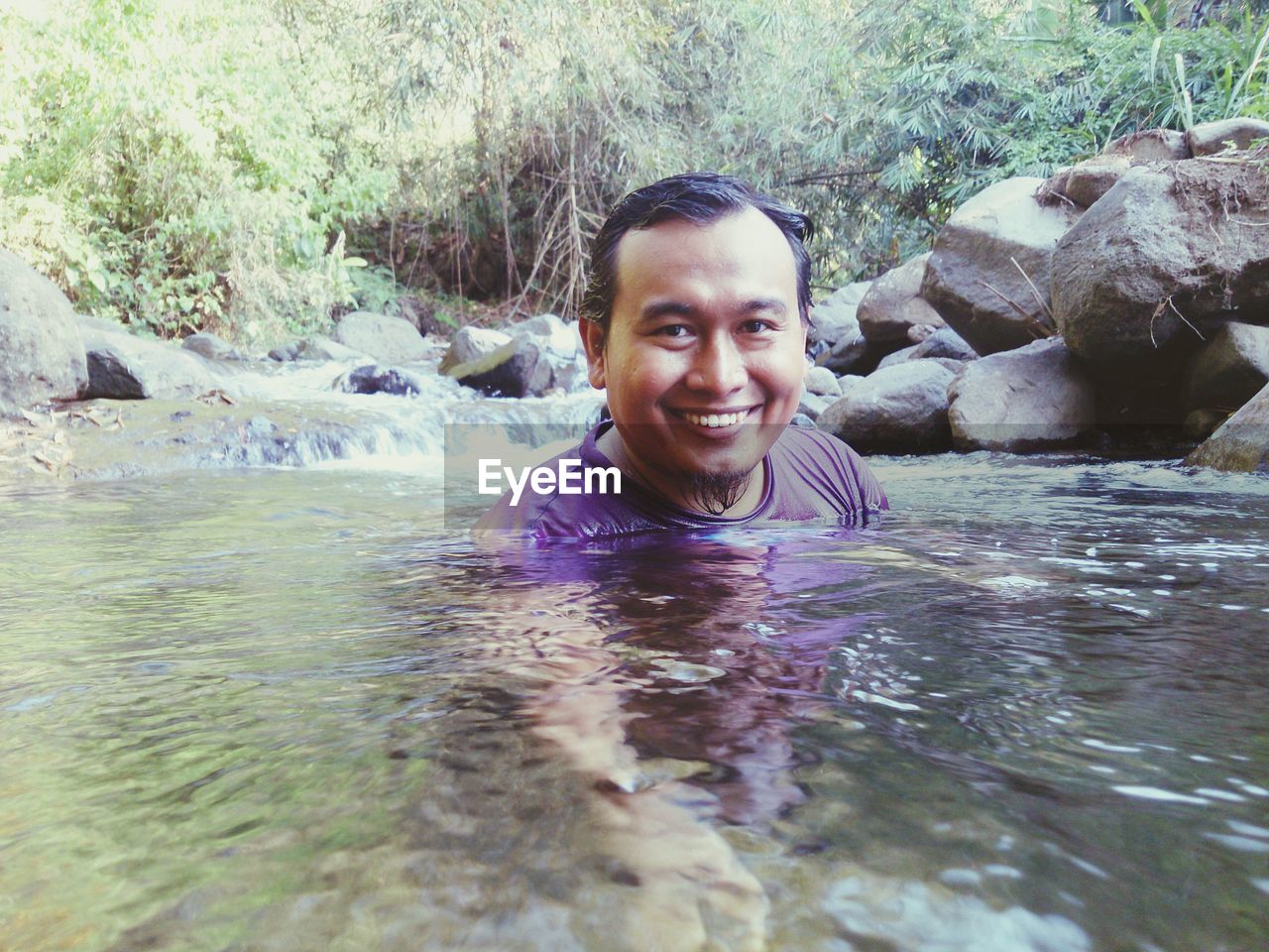 Portrait of happy man swimming in river