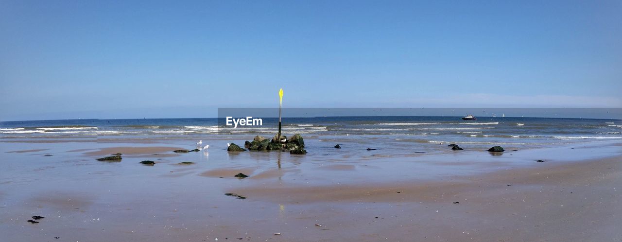 VIEW OF CALM BEACH AGAINST CLEAR SKY