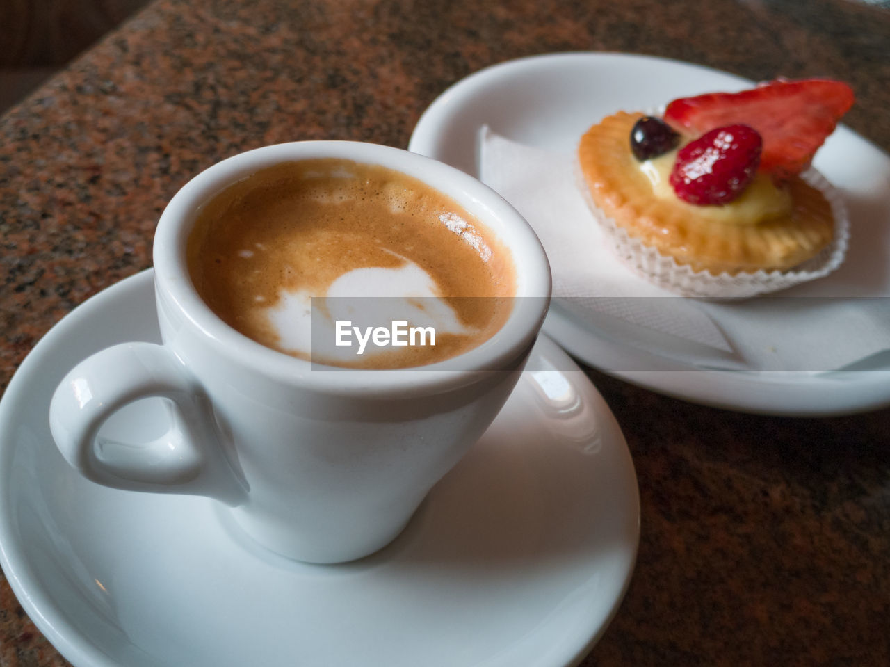 HIGH ANGLE VIEW OF COFFEE AND CUP ON CAKE