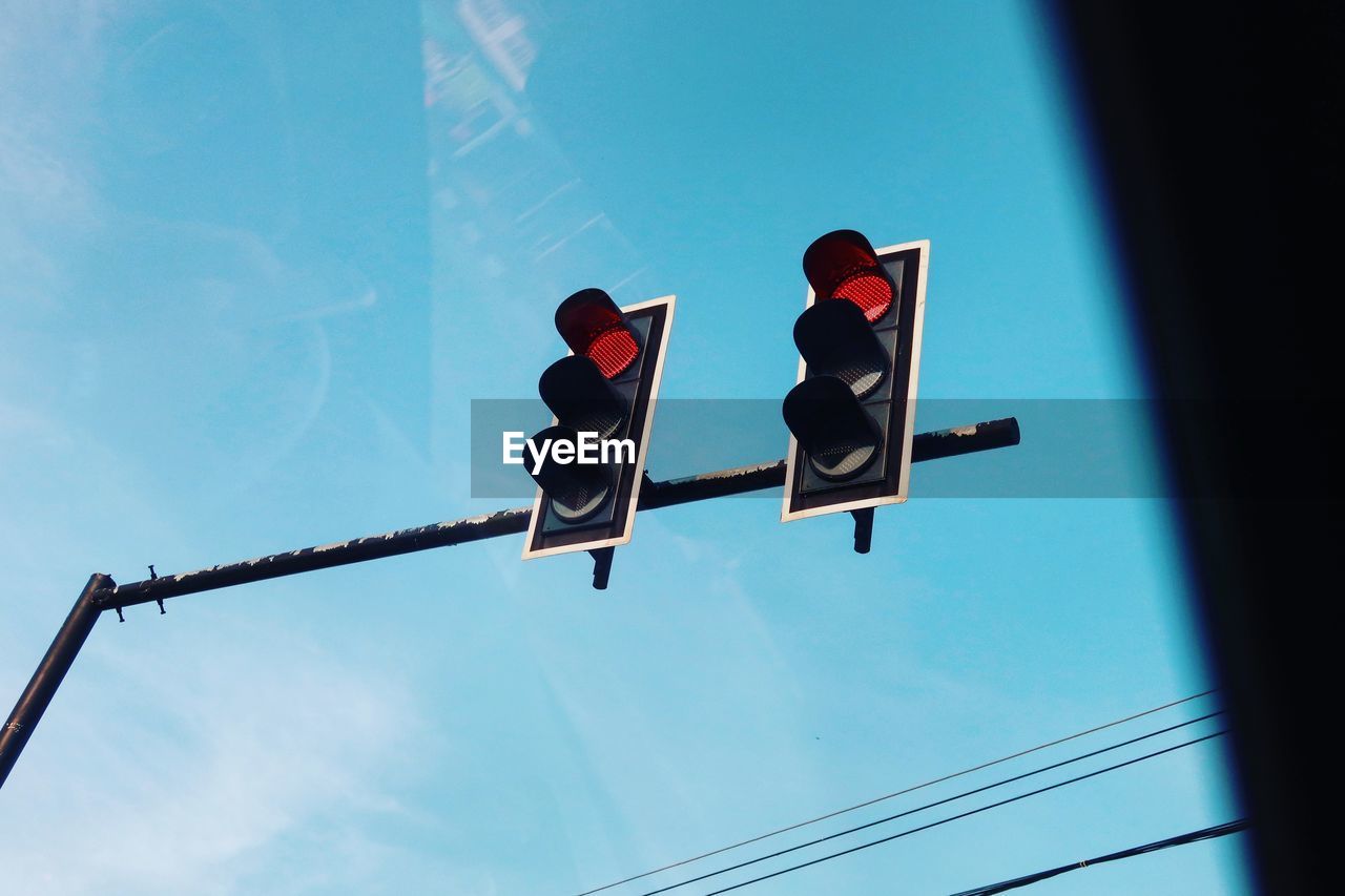 Low angle view of road sign against blue sky