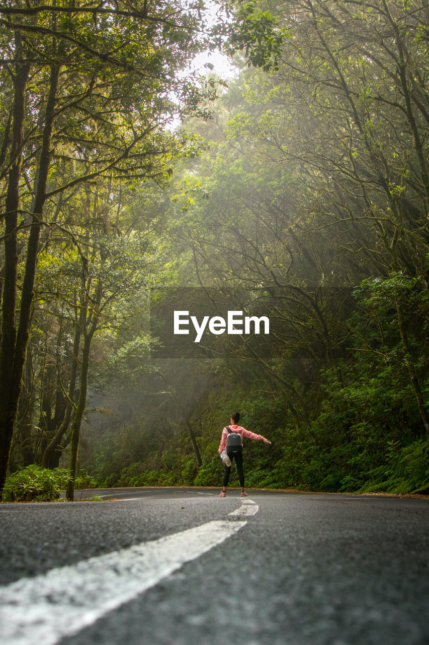 MAN RUNNING ON ROAD IN FOREST