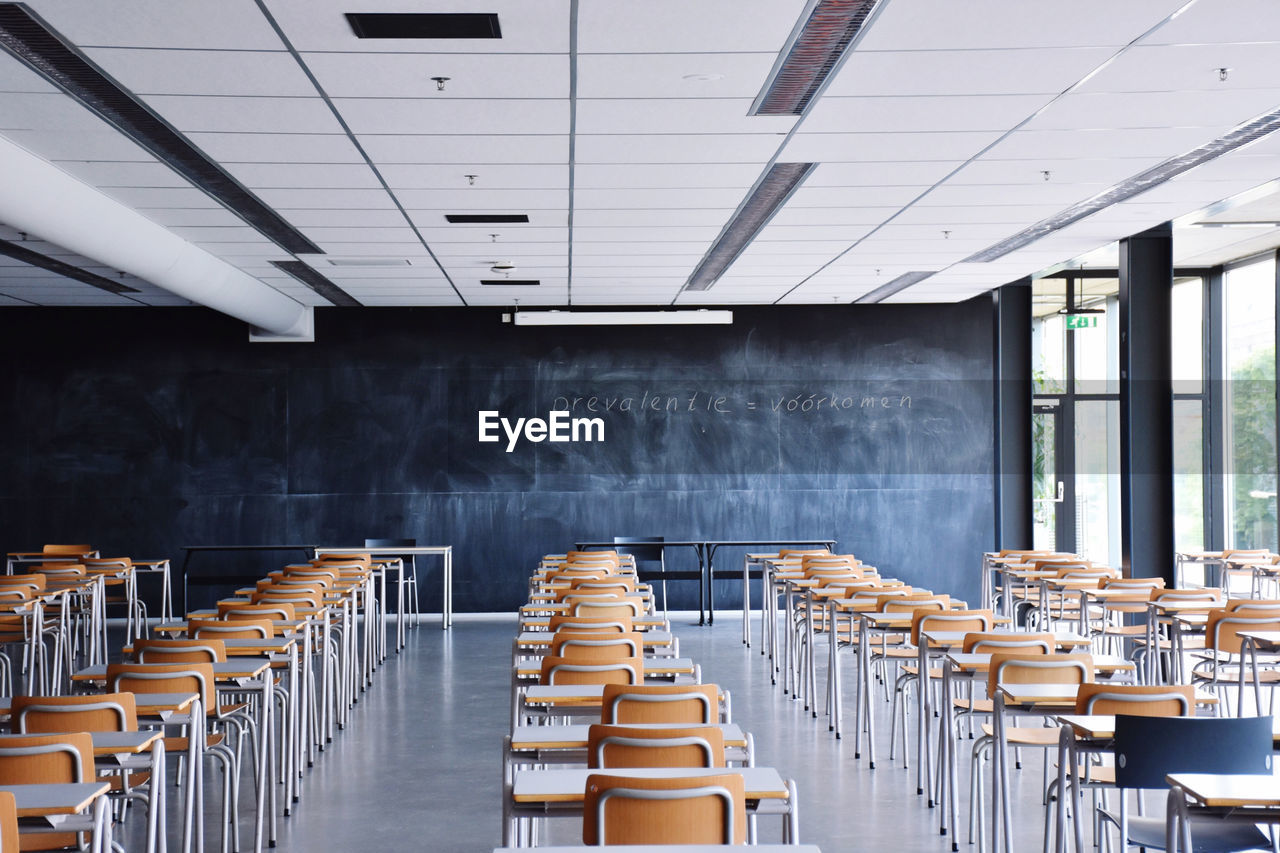 Empty chairs and tables in row at lecture room