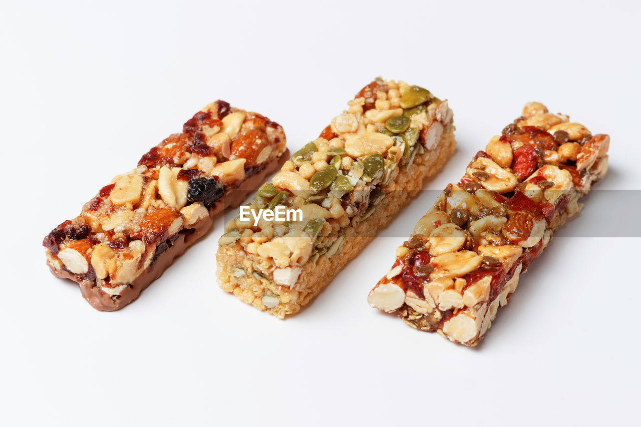 Three protein bars with cereals isolated on a white background close-up.