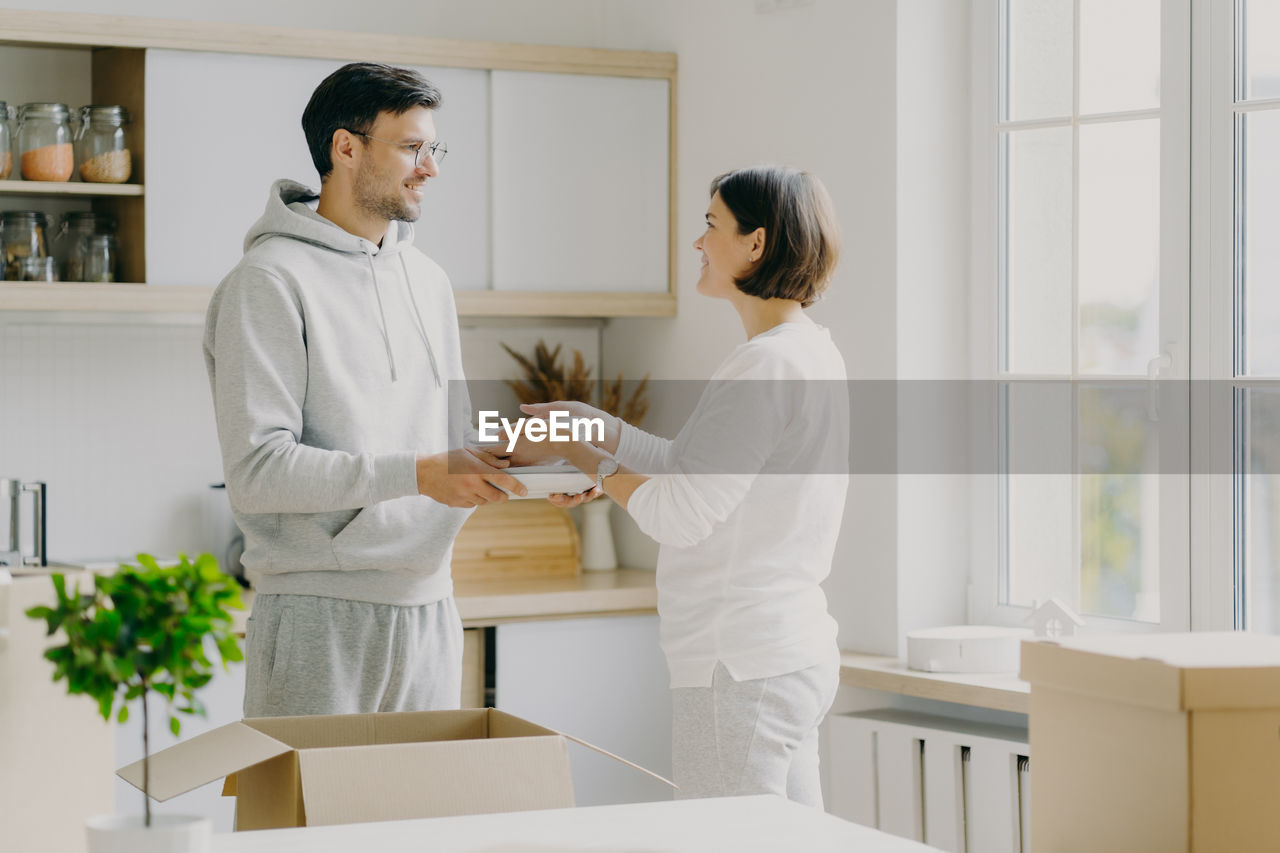 Couple looking at each other while standing at new home
