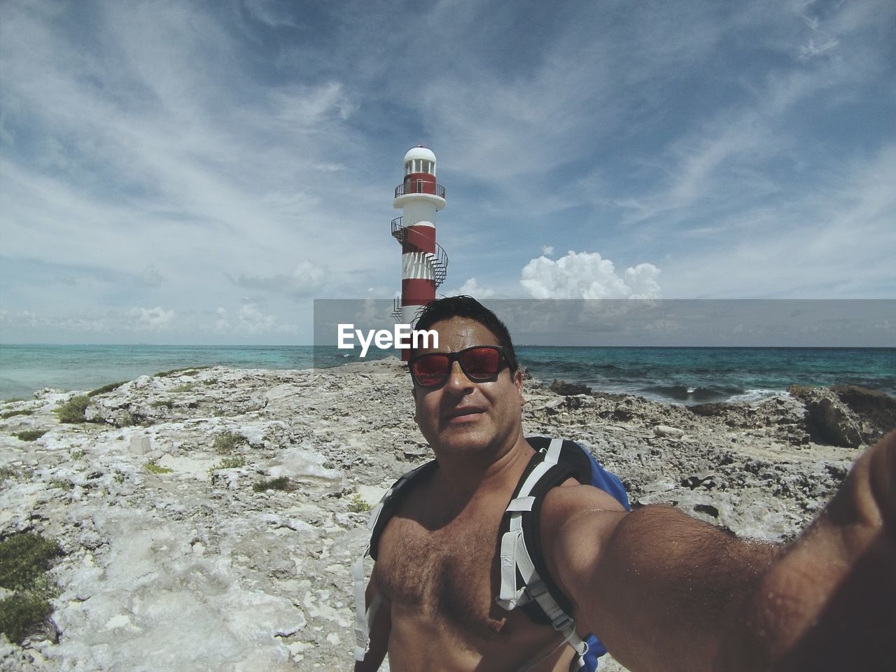 Shirtless man standing at beach