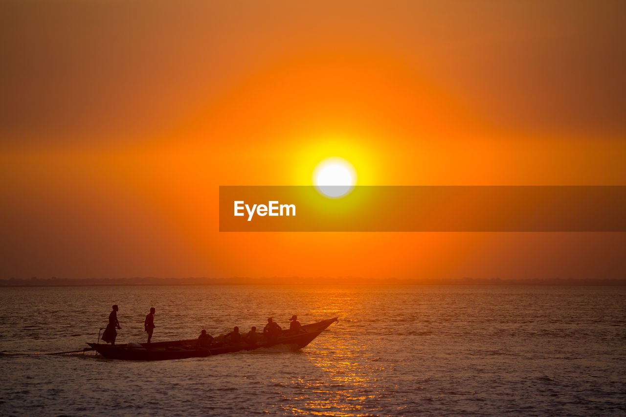 SILHOUETTE BOATS IN SEA AGAINST ORANGE SKY