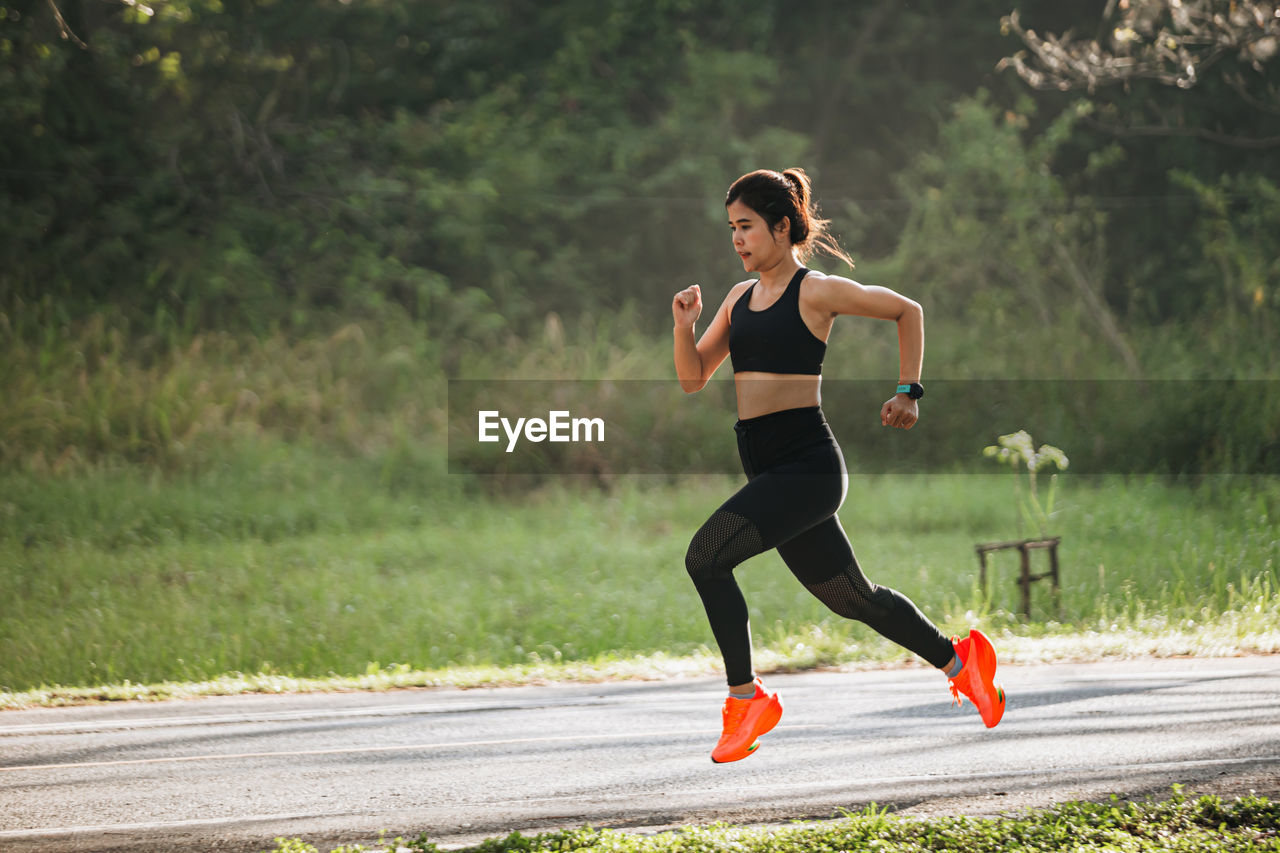 full length of young woman exercising at park