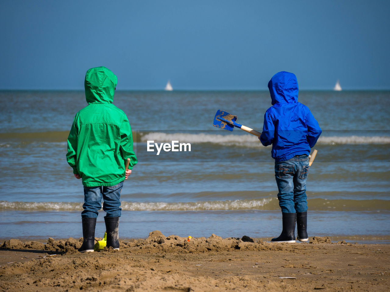 Two boys from behind looking towards the open sea at bray-dunes, france