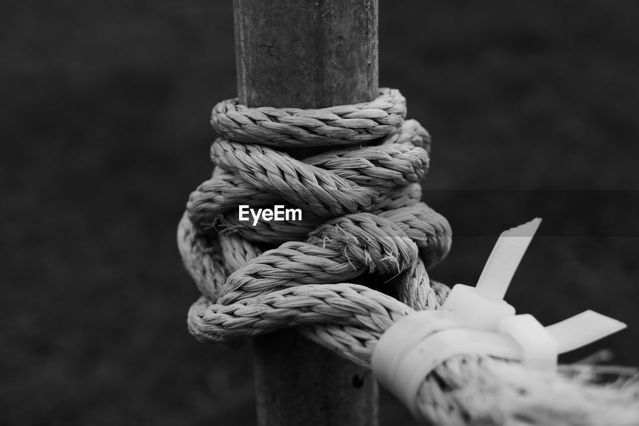 Close-up of roped tied to metallic pole