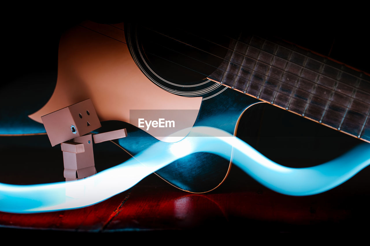 HIGH ANGLE VIEW OF GUITAR AGAINST BLACK BACKGROUND