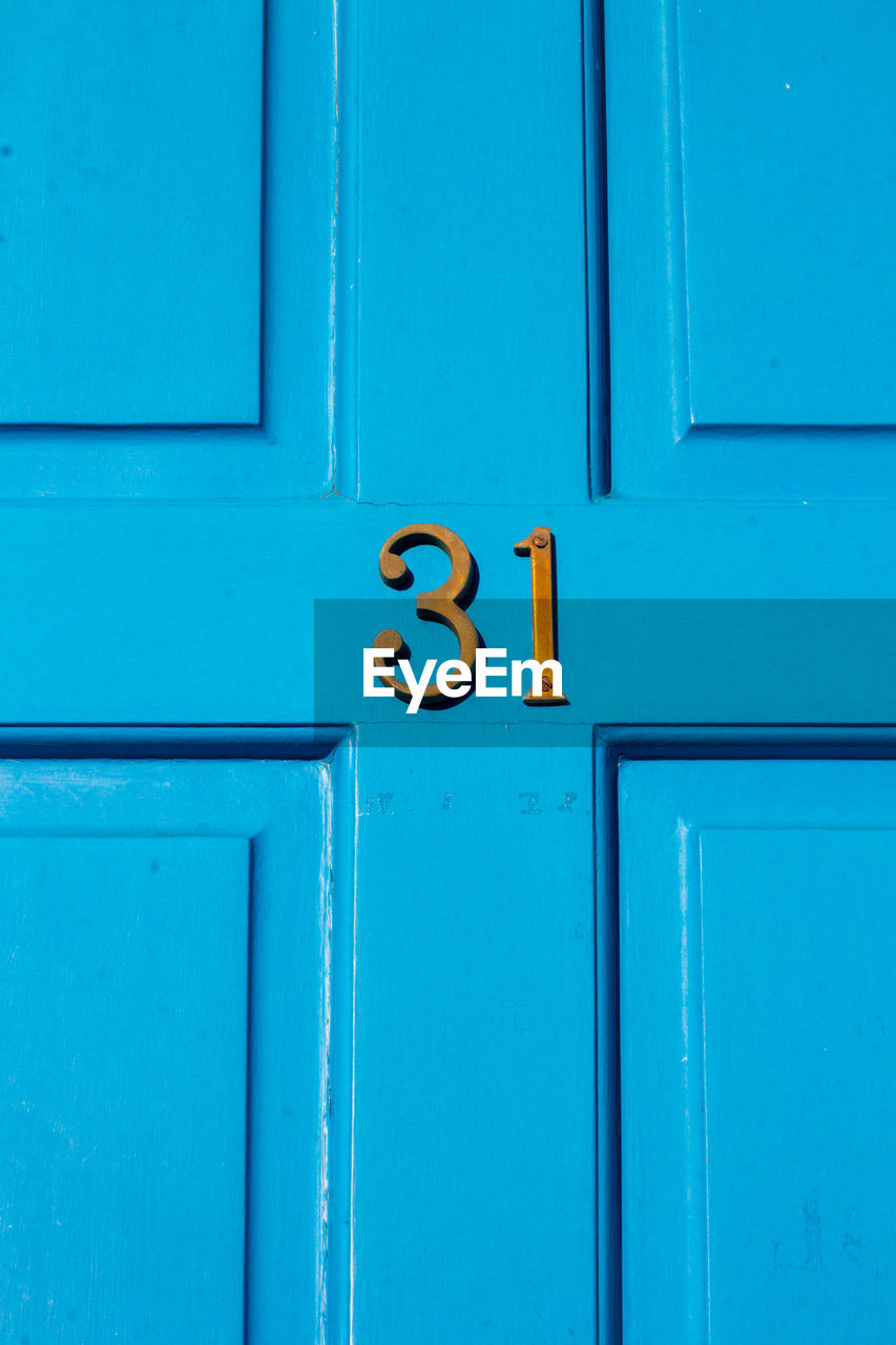 House number 31 on a blue wooden front door in london 