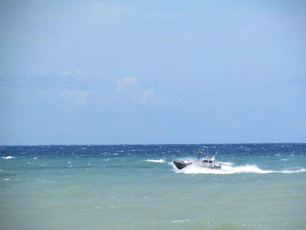 Motorboat in sea against blue sky