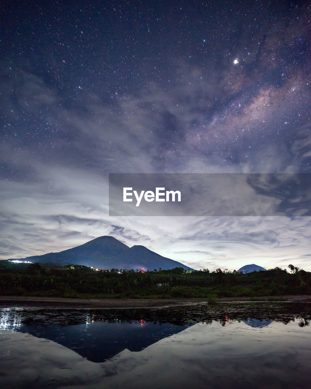 Scenic view of lake against sky at night