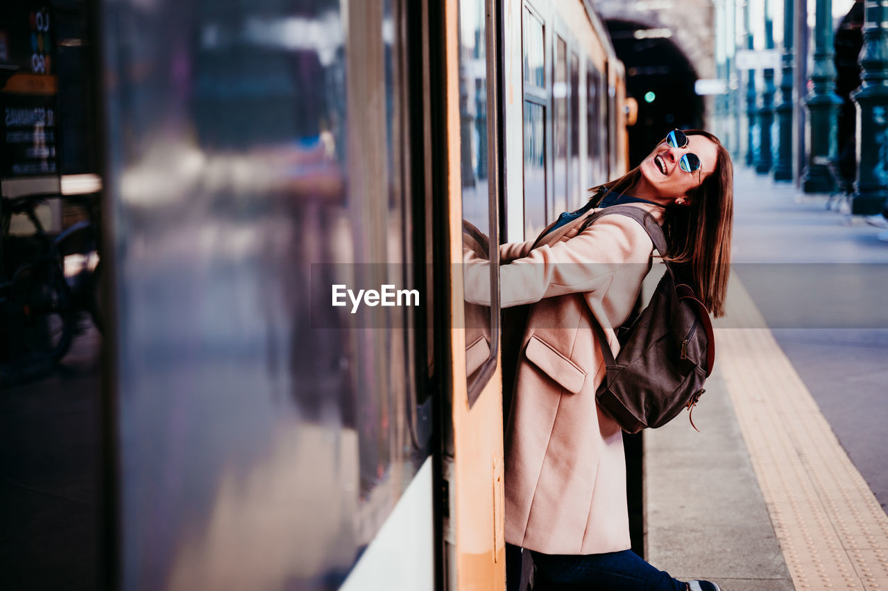 Portrait of happy woman standing in train