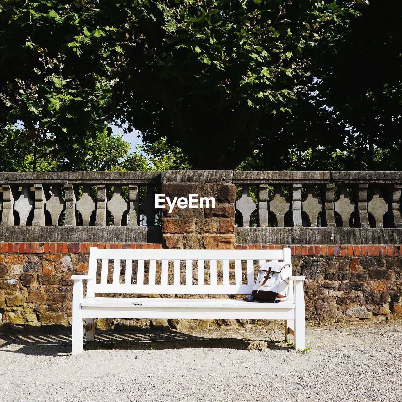 Bag on wooden bench against surrounding wall