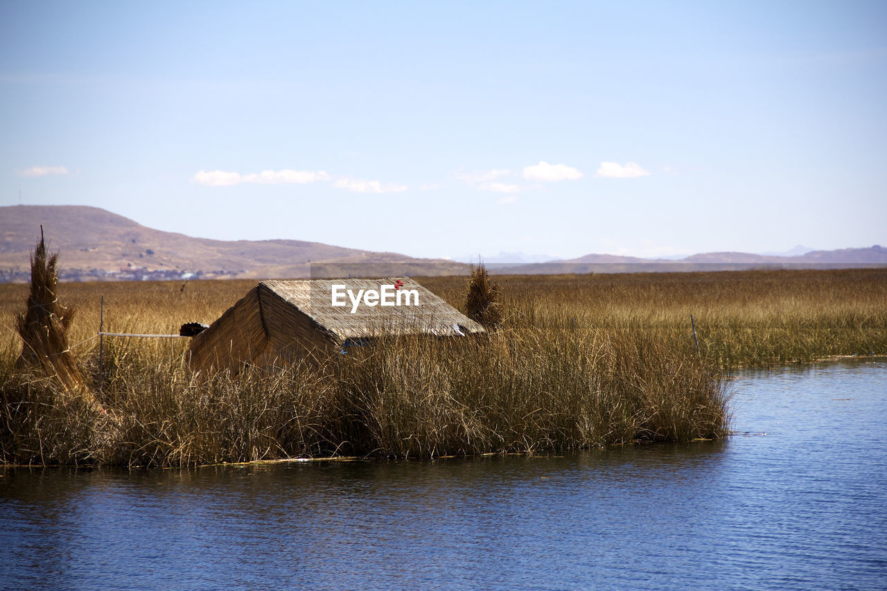 Scenic view of lake and houses against sky