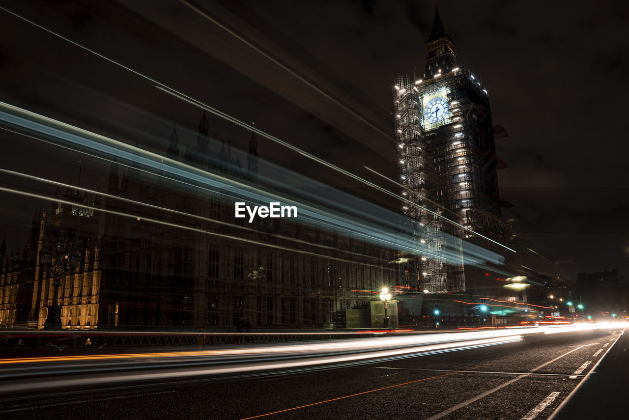 The palace of westminster and illuminated big ben at night with light trail