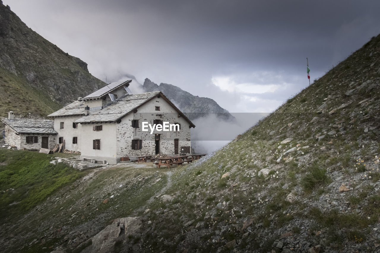 Houses by mountain against sky